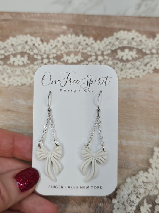 White bow dangle earrings